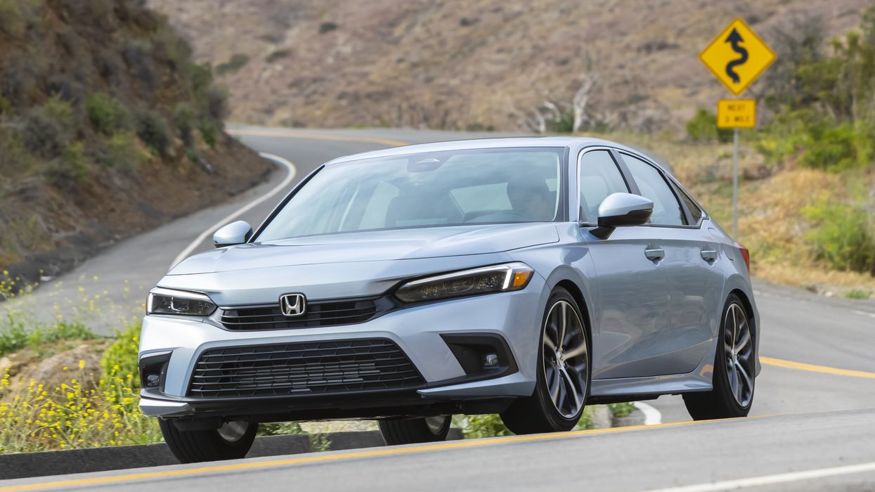 A 2023 Honda Civic driving on a winding road.