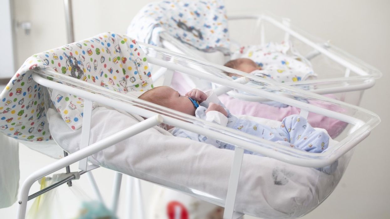 A baby sleeping in a hospital bed shortly after childbirth.