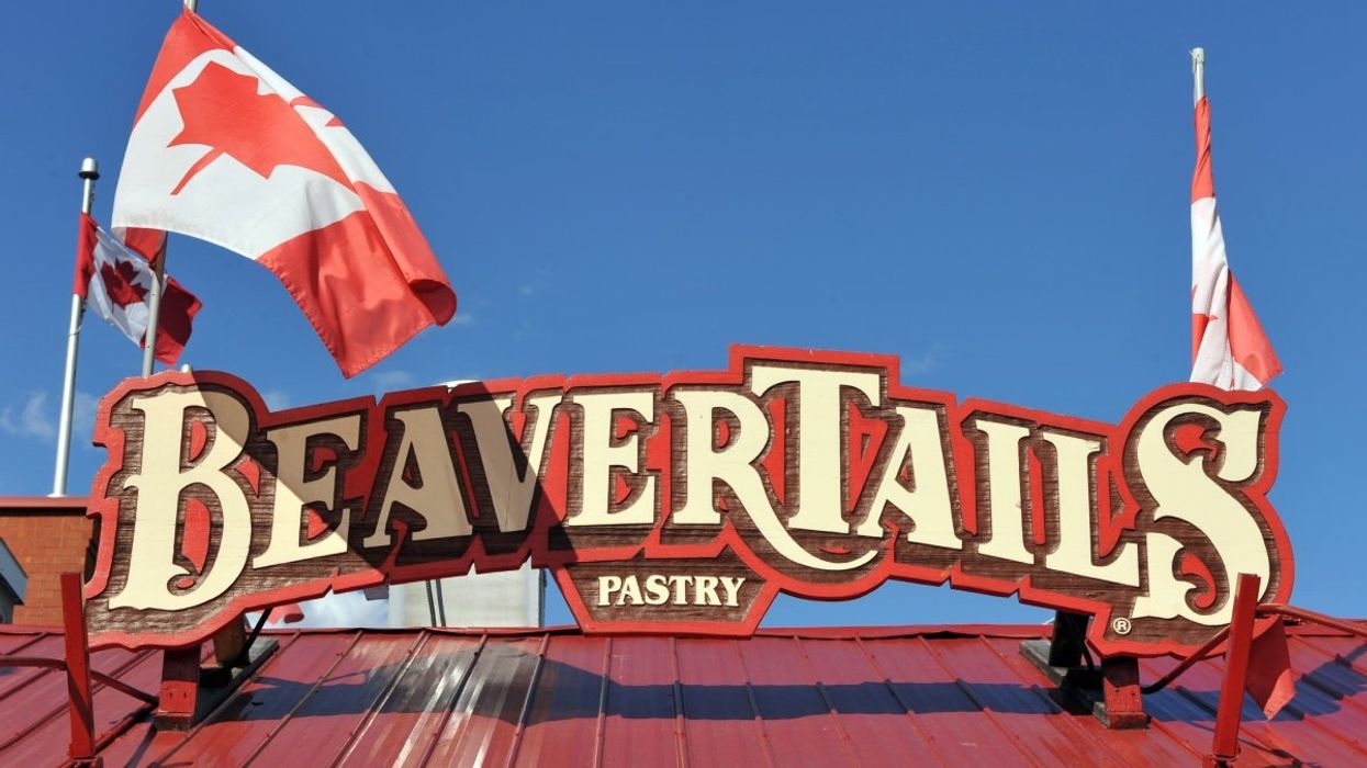 A Beaver Tails restaurants in Ottawa with two Canadian flags waving on its rooftop.