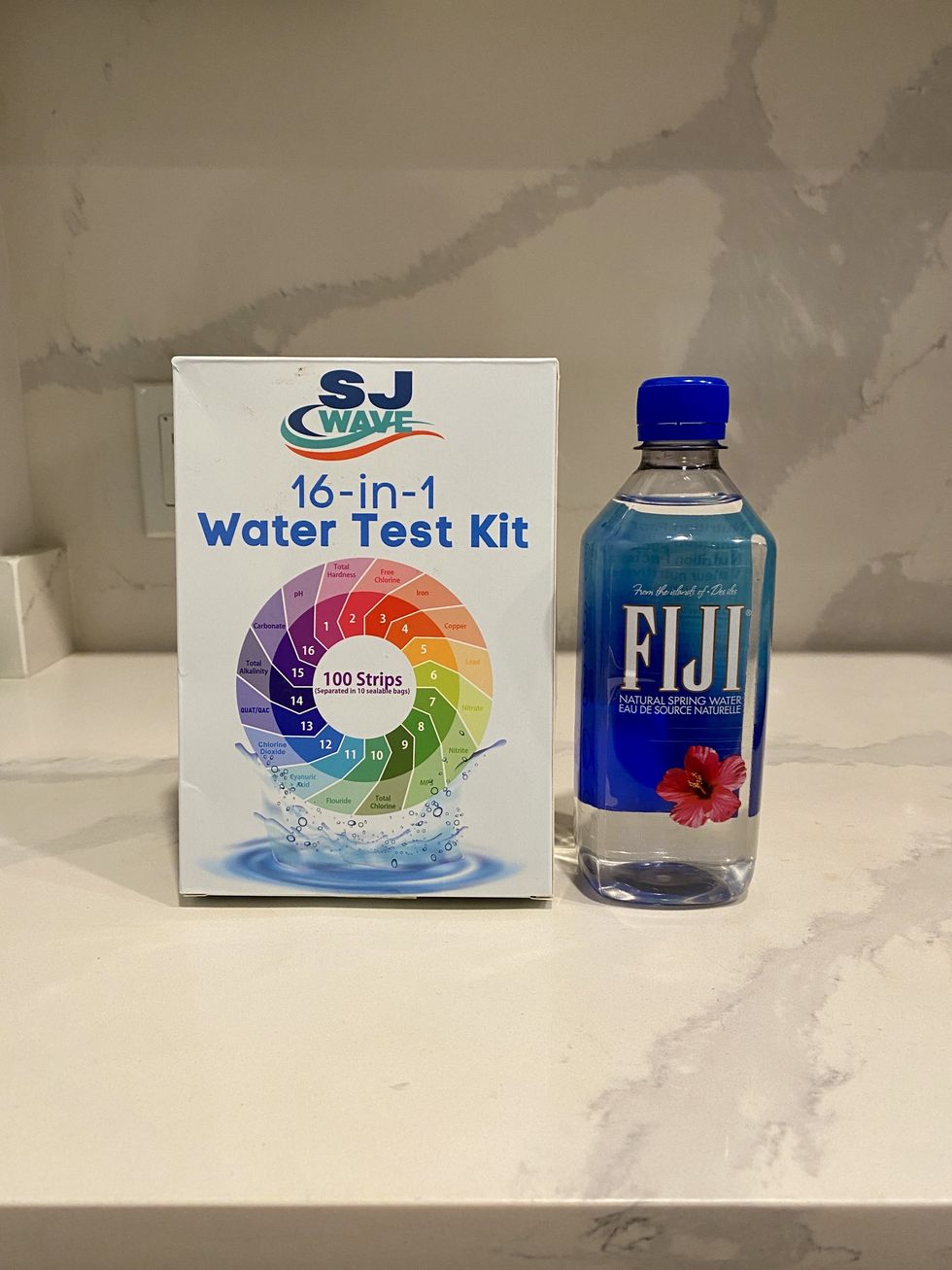 A bottle of Fiji water and a 16-in-1 water test kit.\u200b