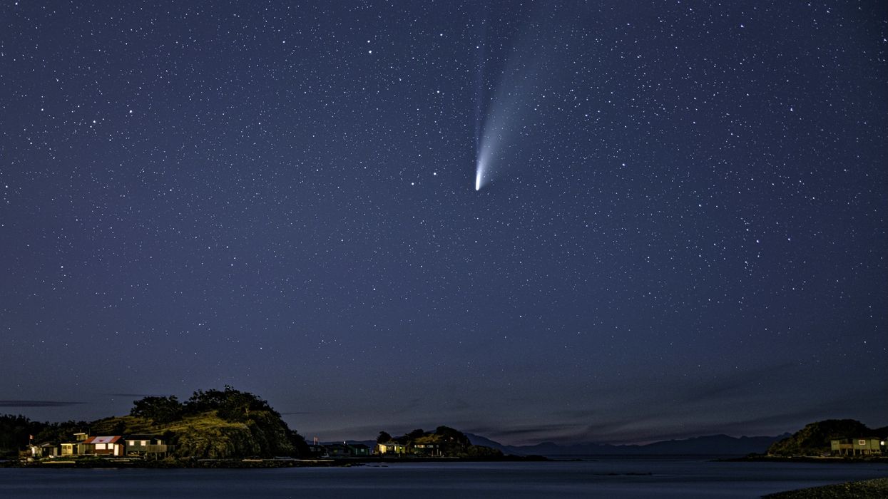 A bright comet in a clear, starry night sky.