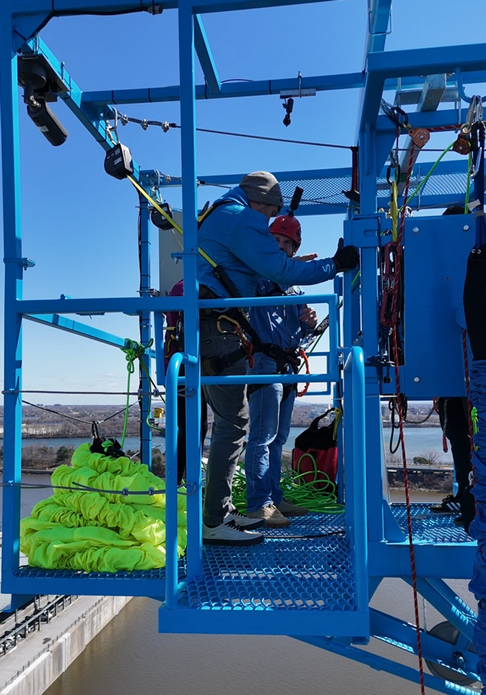 A bungee instructor helps a bungee jumper.