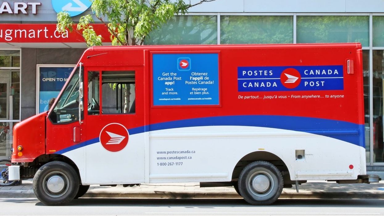 A Canada Post delivery truck parked outside of a Shopper's Drug Mart in Canada.