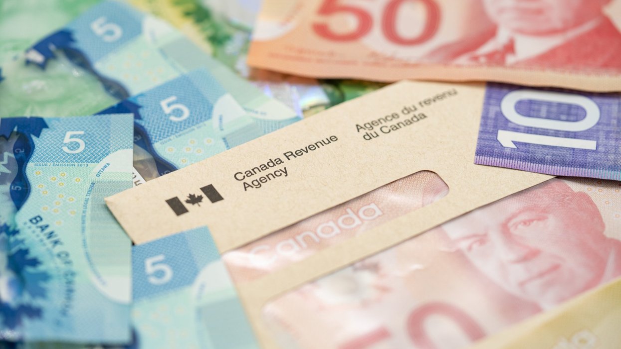 A Canada Revenue Agency envelope filled with Canadian money.