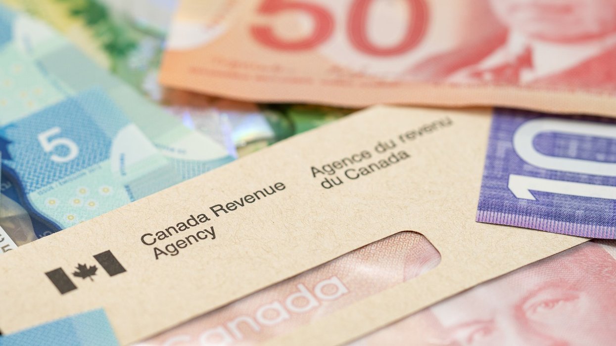 A Canada Revenue Agency envelope filled with Canadian money.