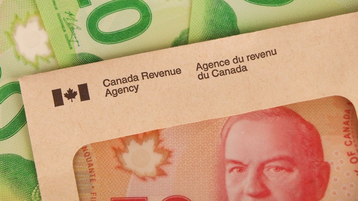 A Canadian $50 bill inside a Canada Revenue Agency envelope surrounded by $20 Canadian banknotes.