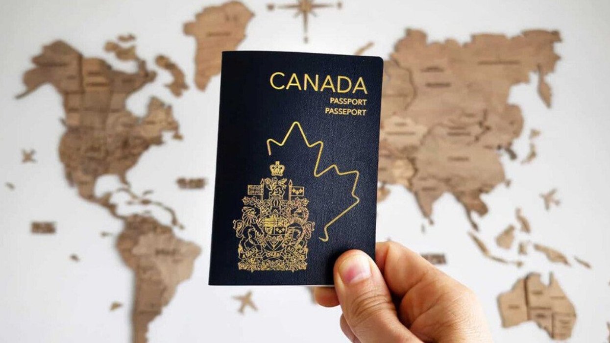 A Canadian passport in front of a world map