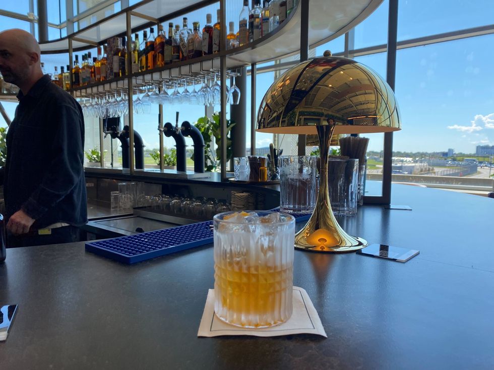 A cocktail sits on a bar counter.