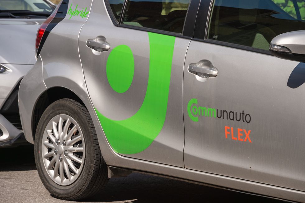 A Communauto car sits in a parking lot.