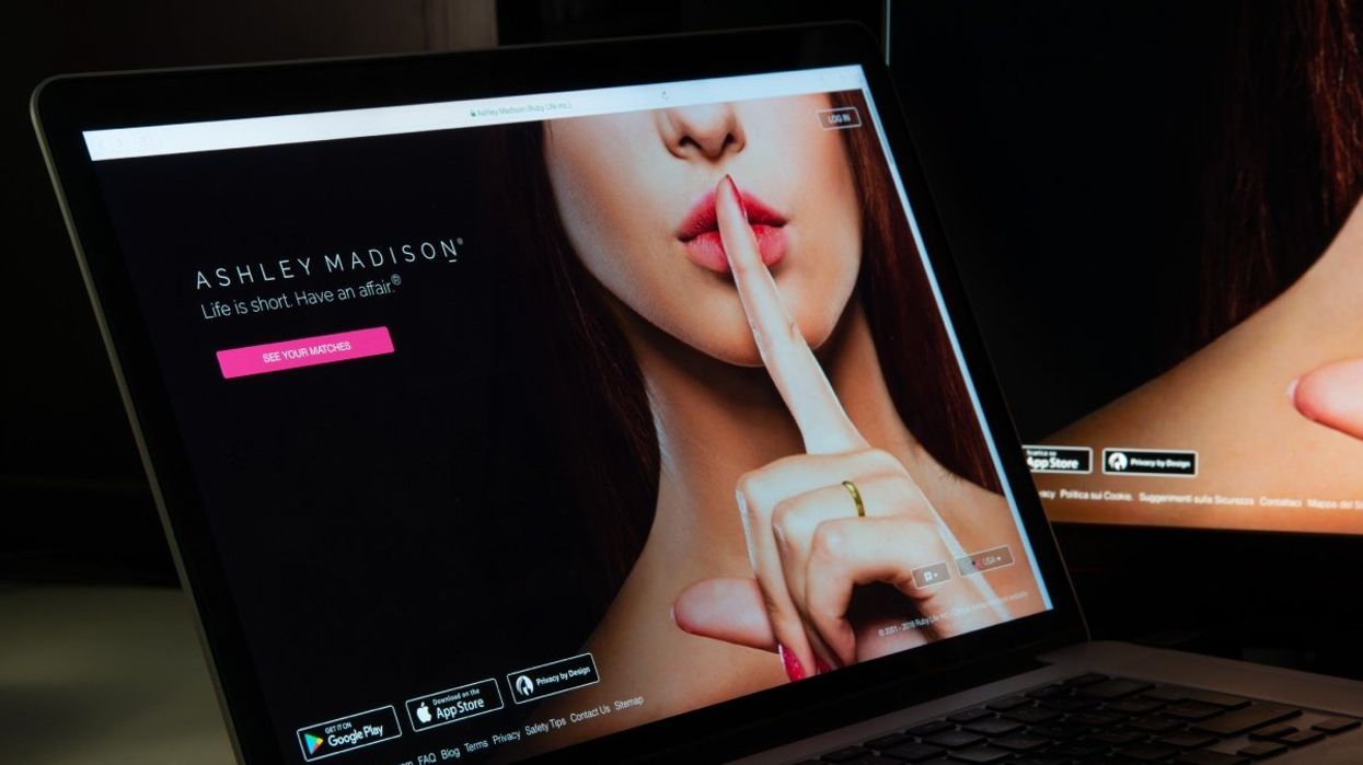 A computer screen with the Ashley Madison homepage on display.