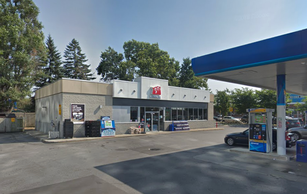 A Couche-Tard convenience store attached to a gas station with several cars pumping their gas.
