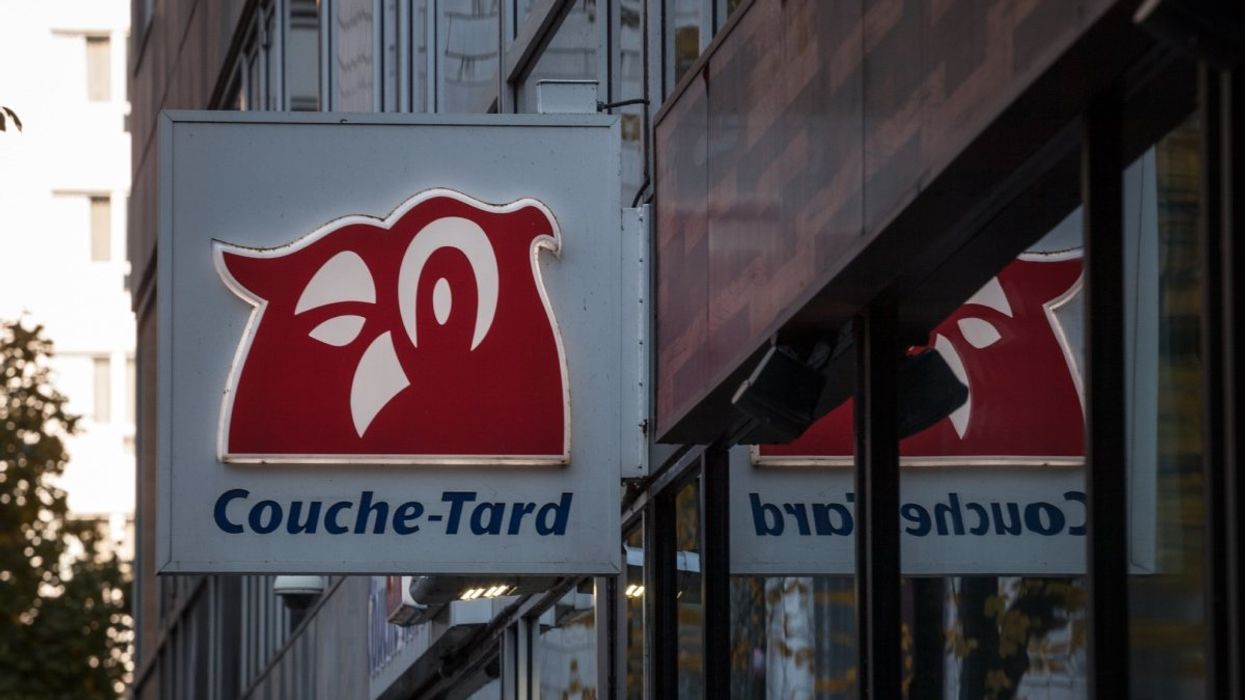 A Couche-Tard sign of a red owl installed in the outside corner of a convenience store in Montreal.