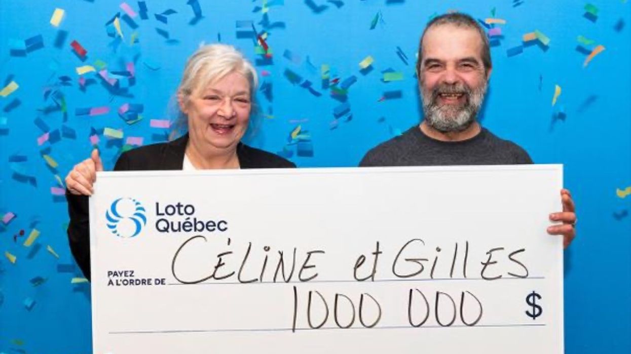 A couple from Quebec posing with their giant cheque for a million dollars from Loto-Quebec.