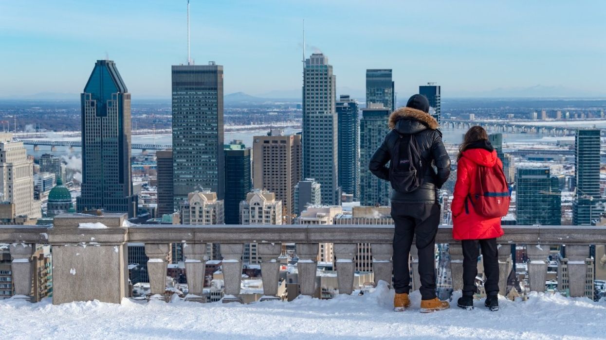 A couple looking out at the Montreal skyline from the Mont-Royal chalet.