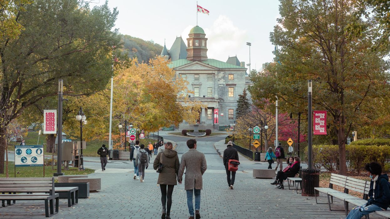 A couple walk hand in hand in front of McGill University, Montreal.