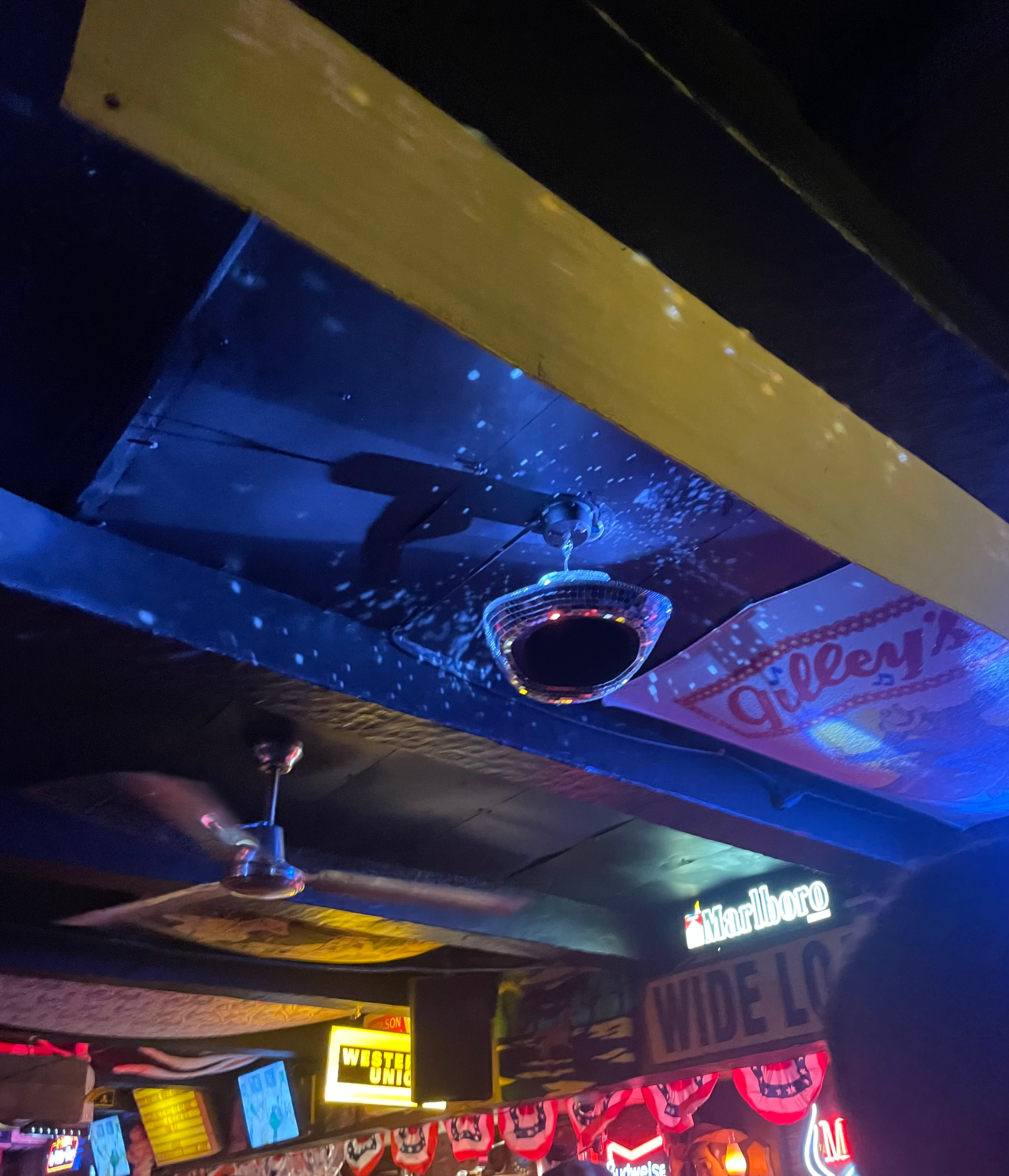 A cowboy hat disco ball spins on the ceiling.