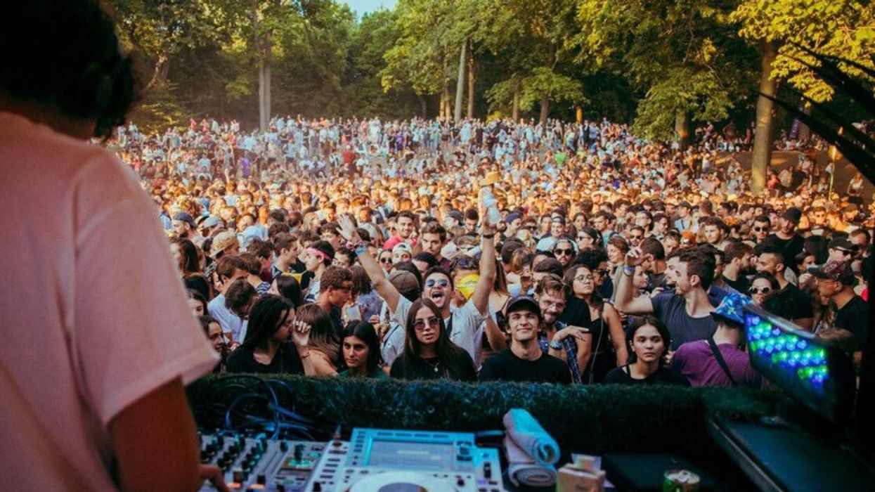 A DJ performs in front of a huge crowd.