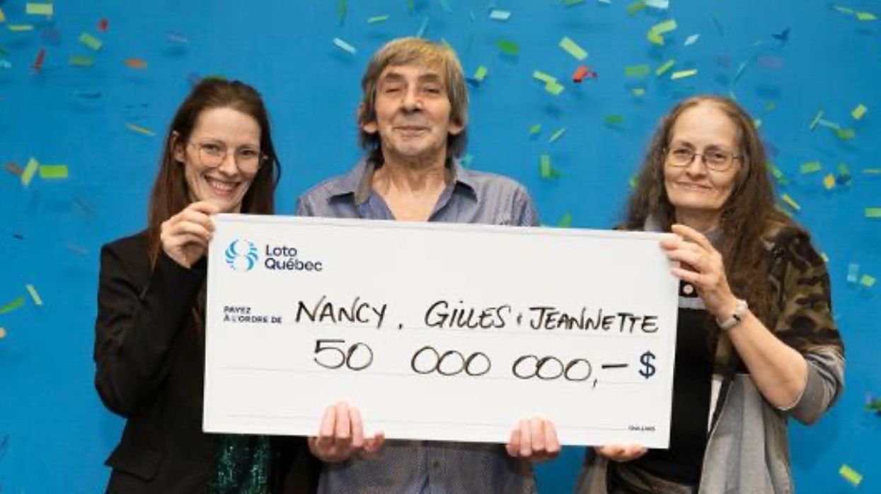 A family from Quebec holding up a giant cheque for $50 million at the Loto-Québec headquarters.