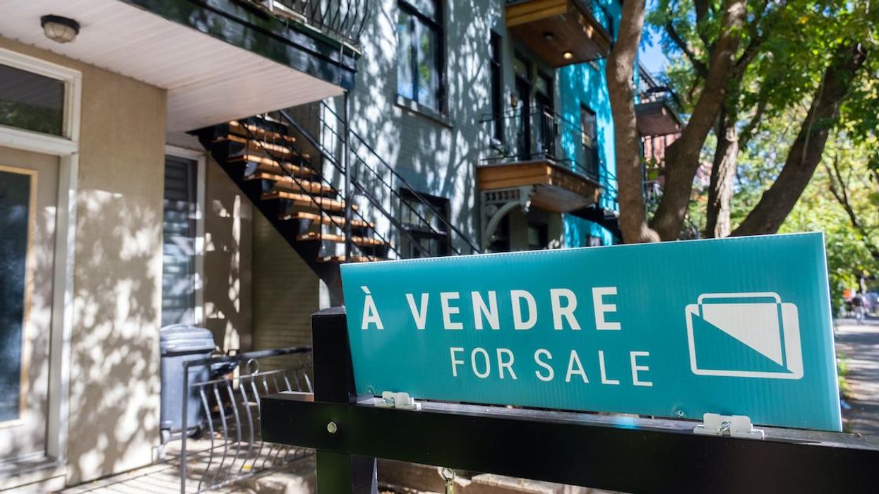 A for sale sign on a residential street in Montreal.