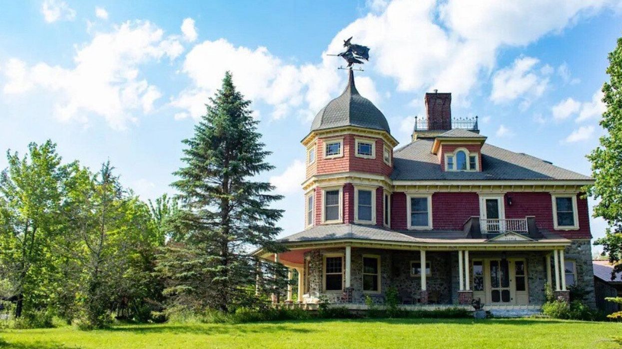 A grand home with a witch weather vane.
