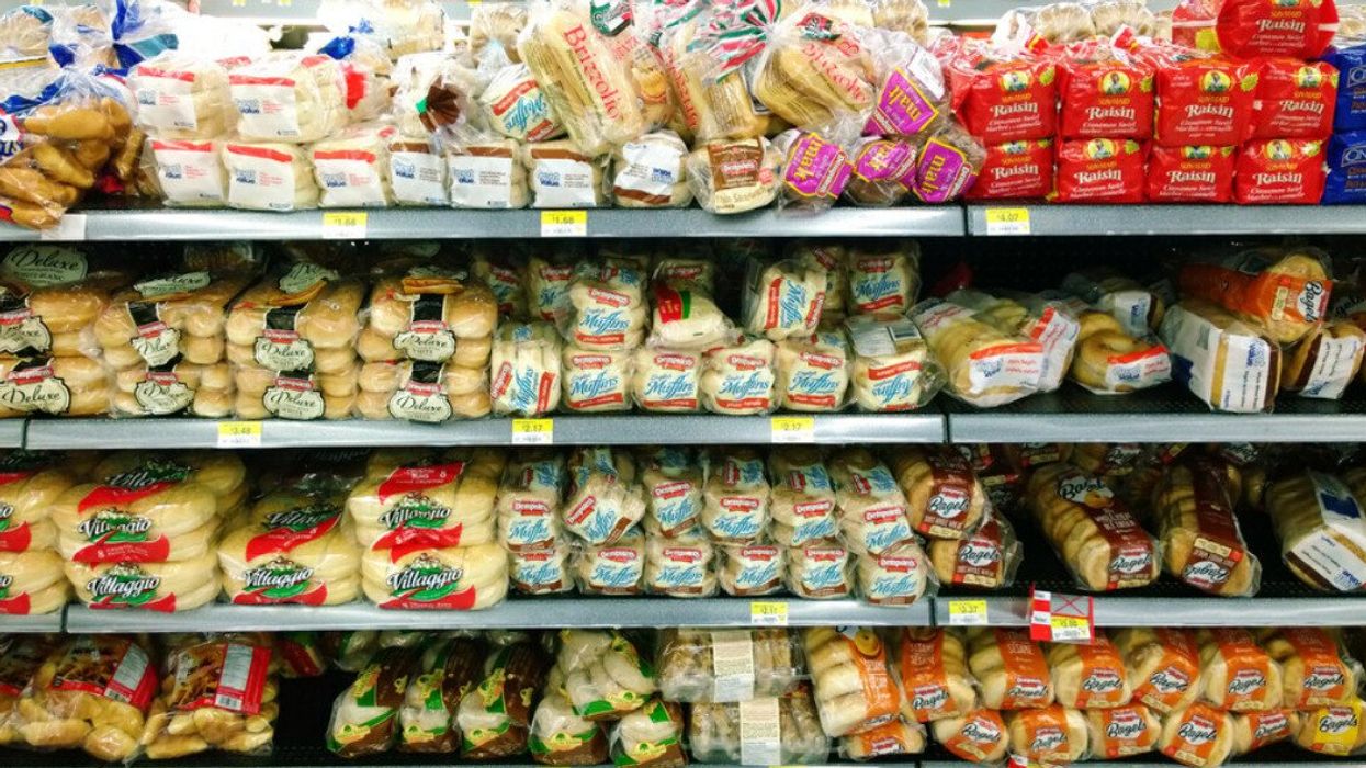 A grocery shelf filled with bread.