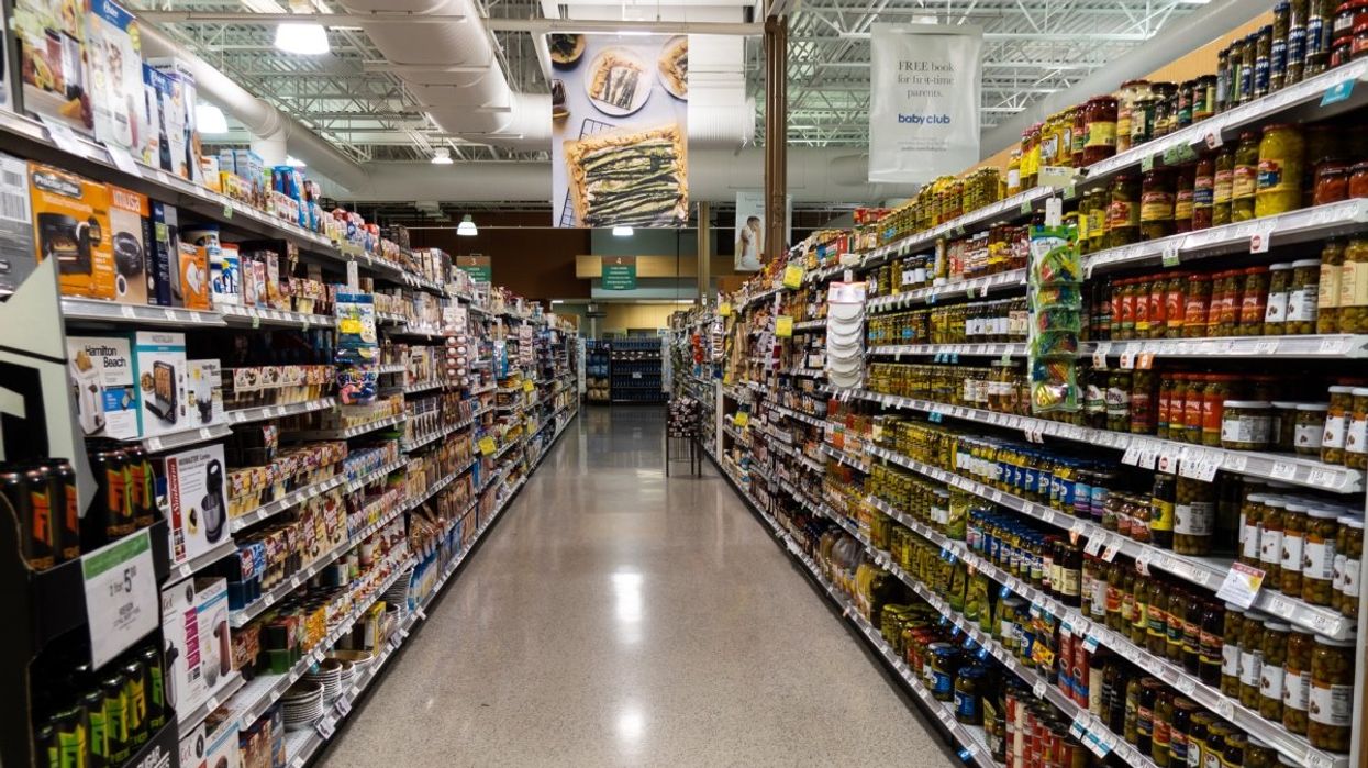 A grocery store aisle filled with non perishable items on the shelves.