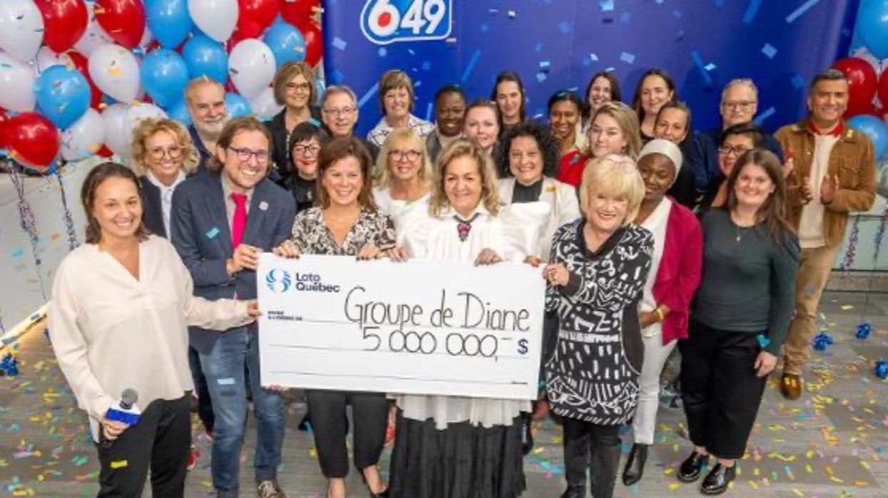 A group of 28 co-workers from the Université de Montréal holding a massive $5 million cheque from Loto-Québec.