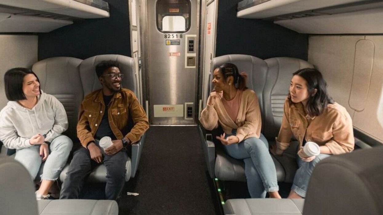 A group of friends sit on a train.