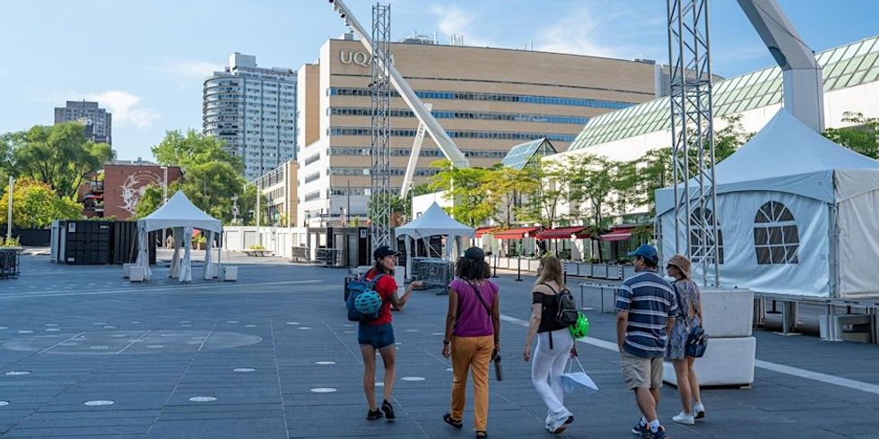 A group of people walking through Quartier des Spectacles in Montreal.