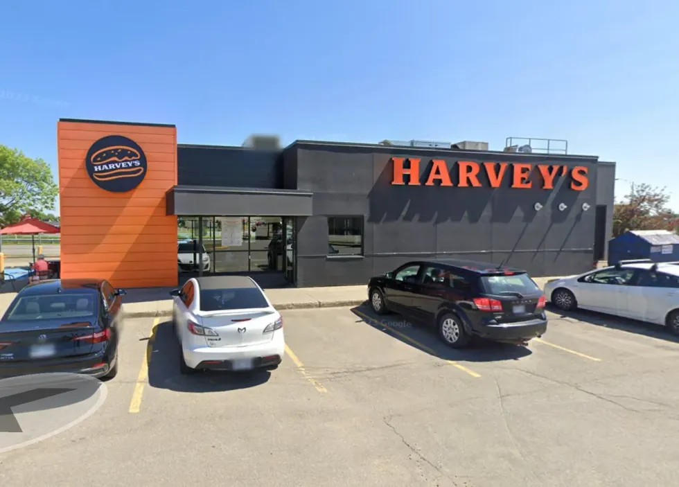 A Harvey's fast food restaurant located in Quebec City with various cars parked in the parking lot.