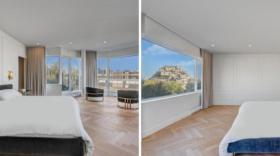 A large bedroom with expansive windows offers stunning views of Habitat 67, along with sleek, minimalist decor that lets the view shine.