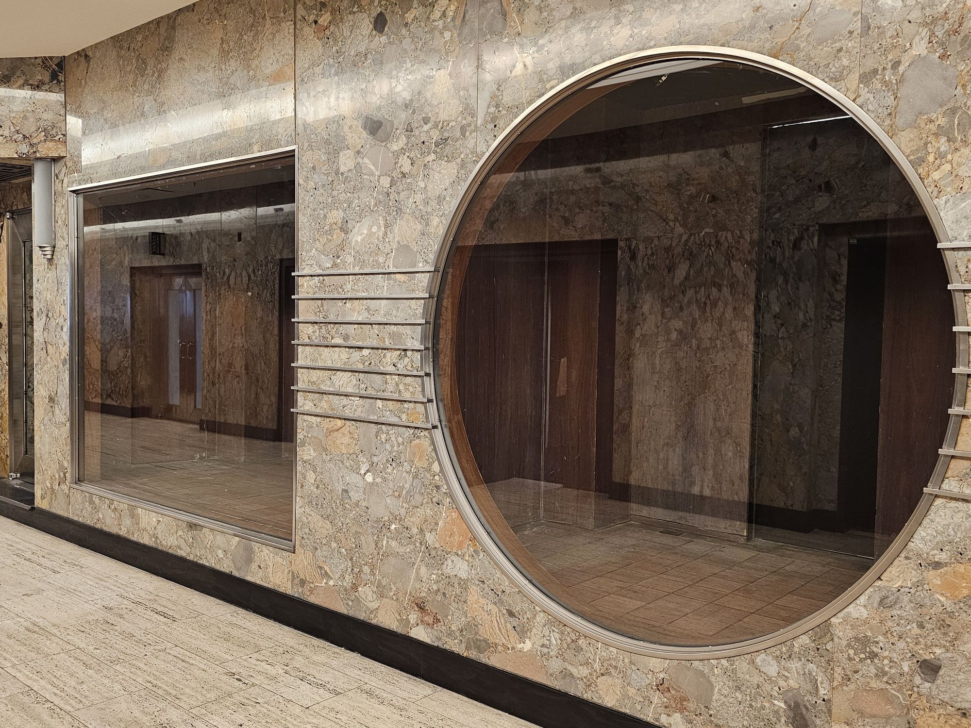 A large circular window at the entrance to Le 9e.