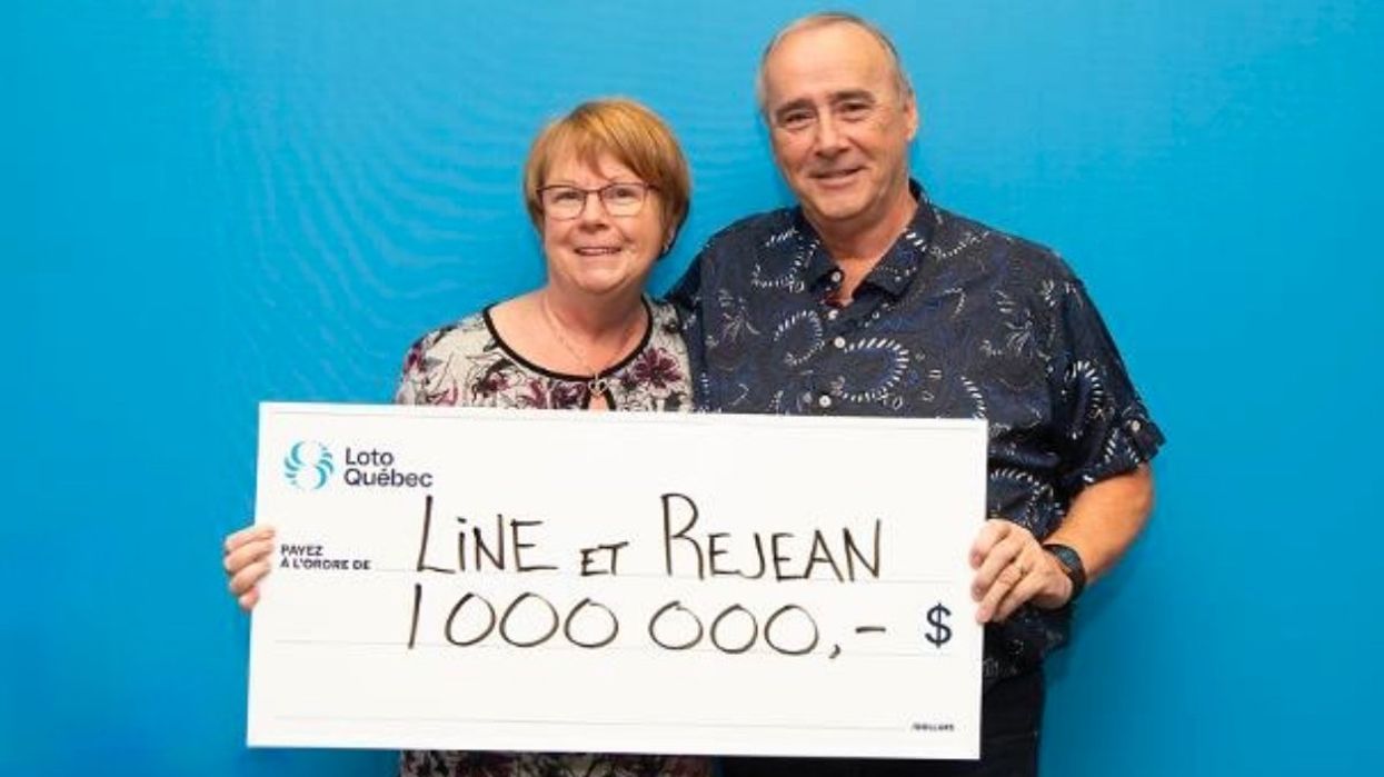 A Laval couple holding a giant cheque for $1,000,000 at Loto-Quebec headquarters.