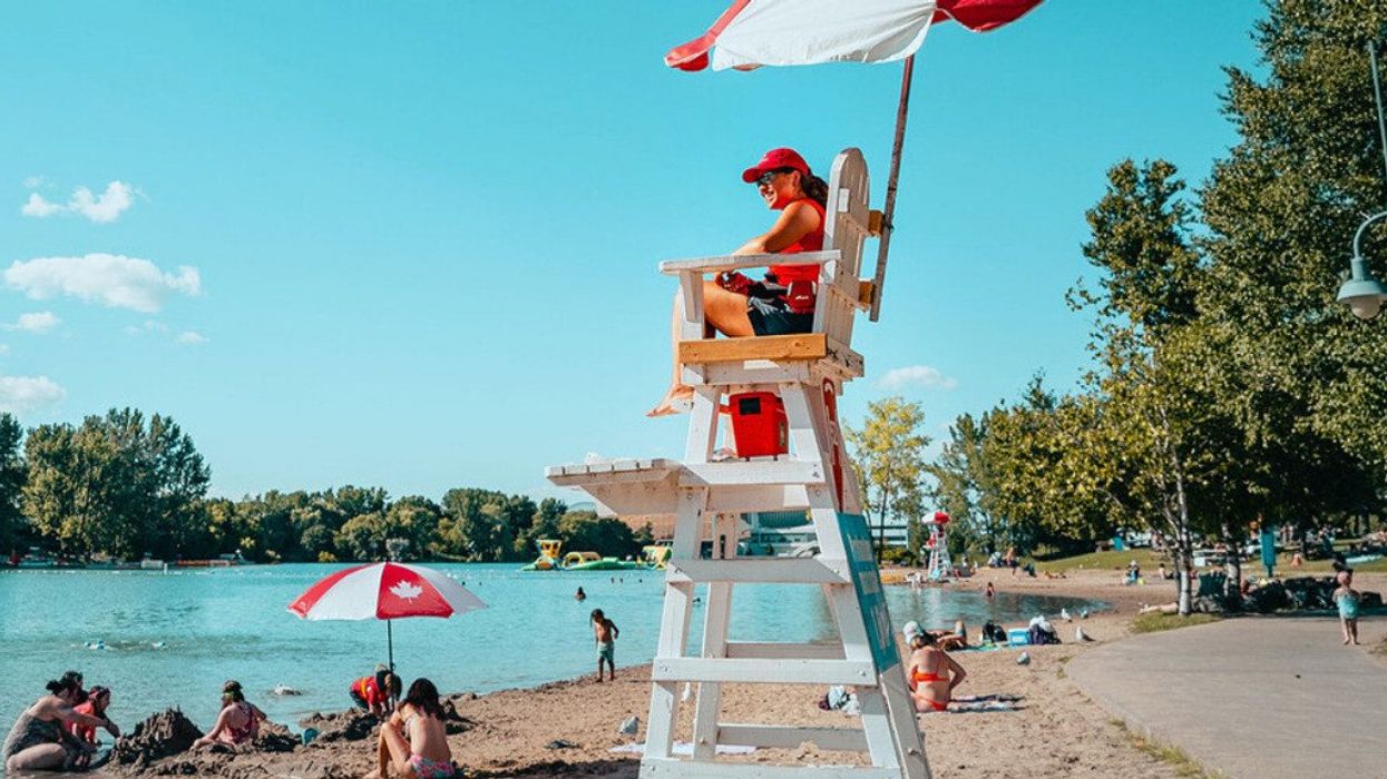 A lifeguard looks out over sunbathers at Jean-Doré Beach.