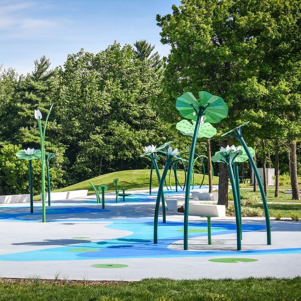 A lily-themed splash pad by the woods.