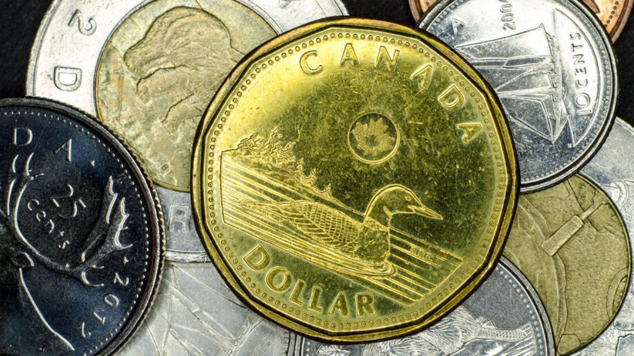 A loonie on top of other Canadian coins.