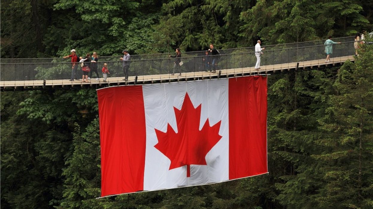 A massive Canadian flag hanging from Capilano Suspension Bridge Park in Vancouver, Canada.