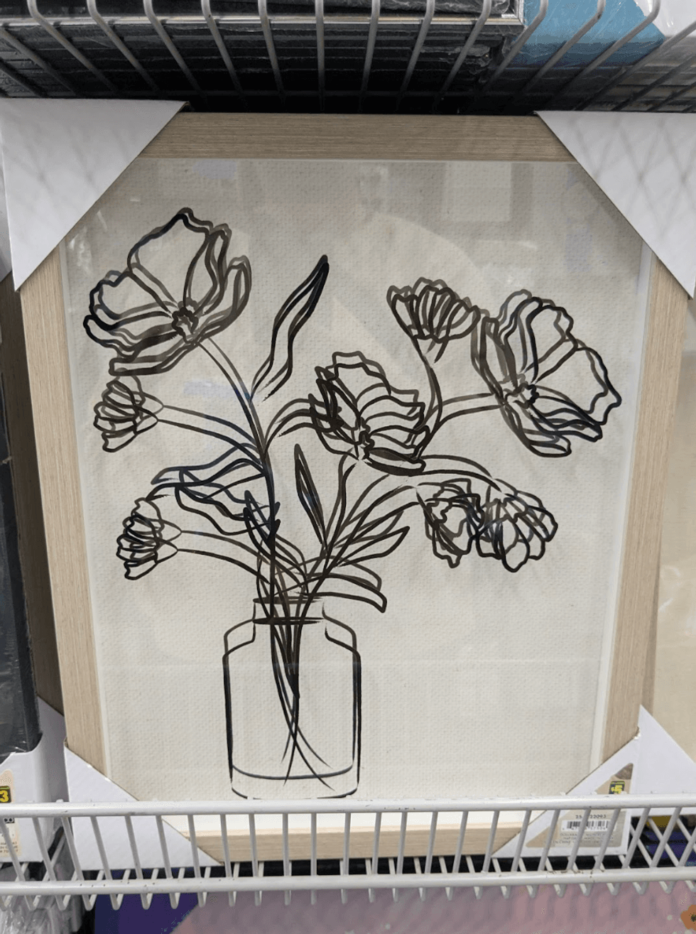 A minimalist line-drawing art print in a wooden frame