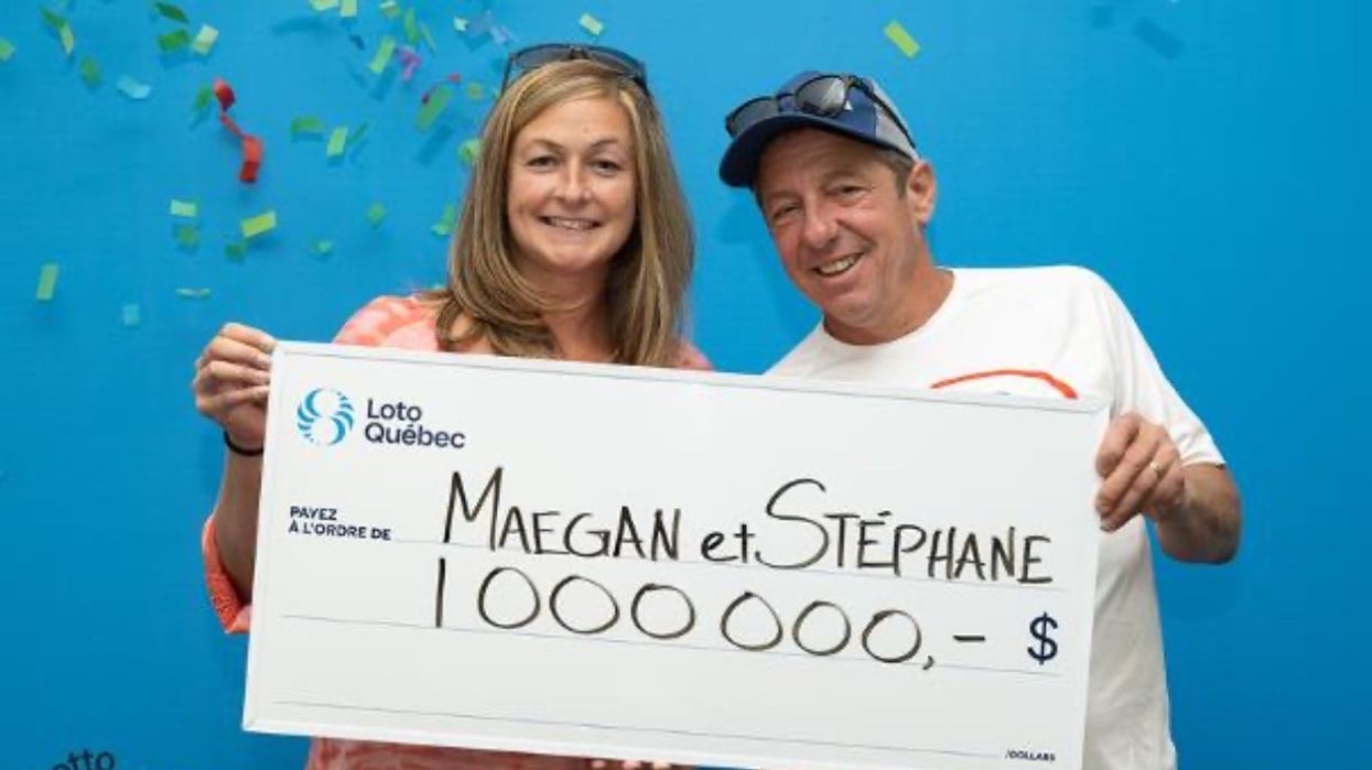 A Montreal couple holding a giant cheque for $1,000,000 at the Loto-Québec headquarters after winning the Lotto Max jackpot.