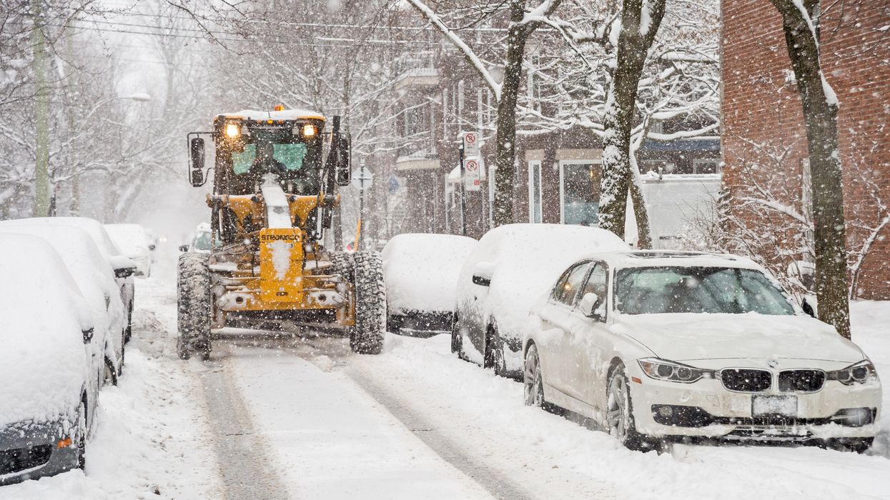 A Montreal snow removal tractor works on a small street.