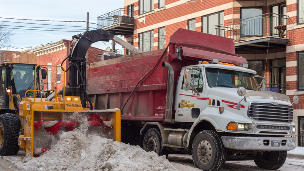 A Montreal snowplow pours snow into a truck.