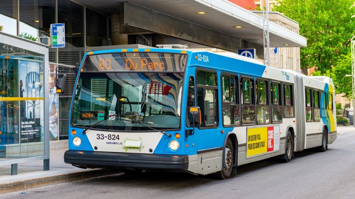 A Montreal STM bus parked outside of the Berri-UQAM Metro station.