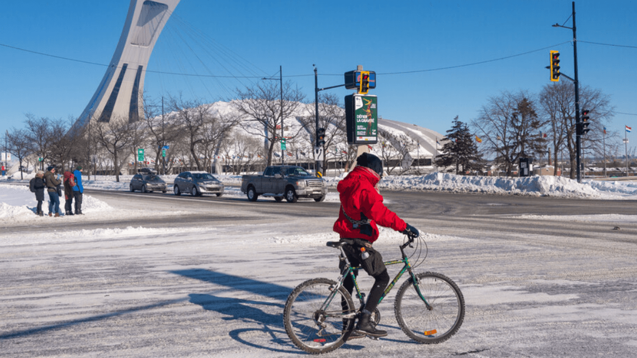 A Montrealer biking in winter near the Olympic stadium.