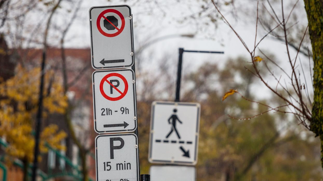 A no parking and 15-minute parking sign on a street lined with fall trees.