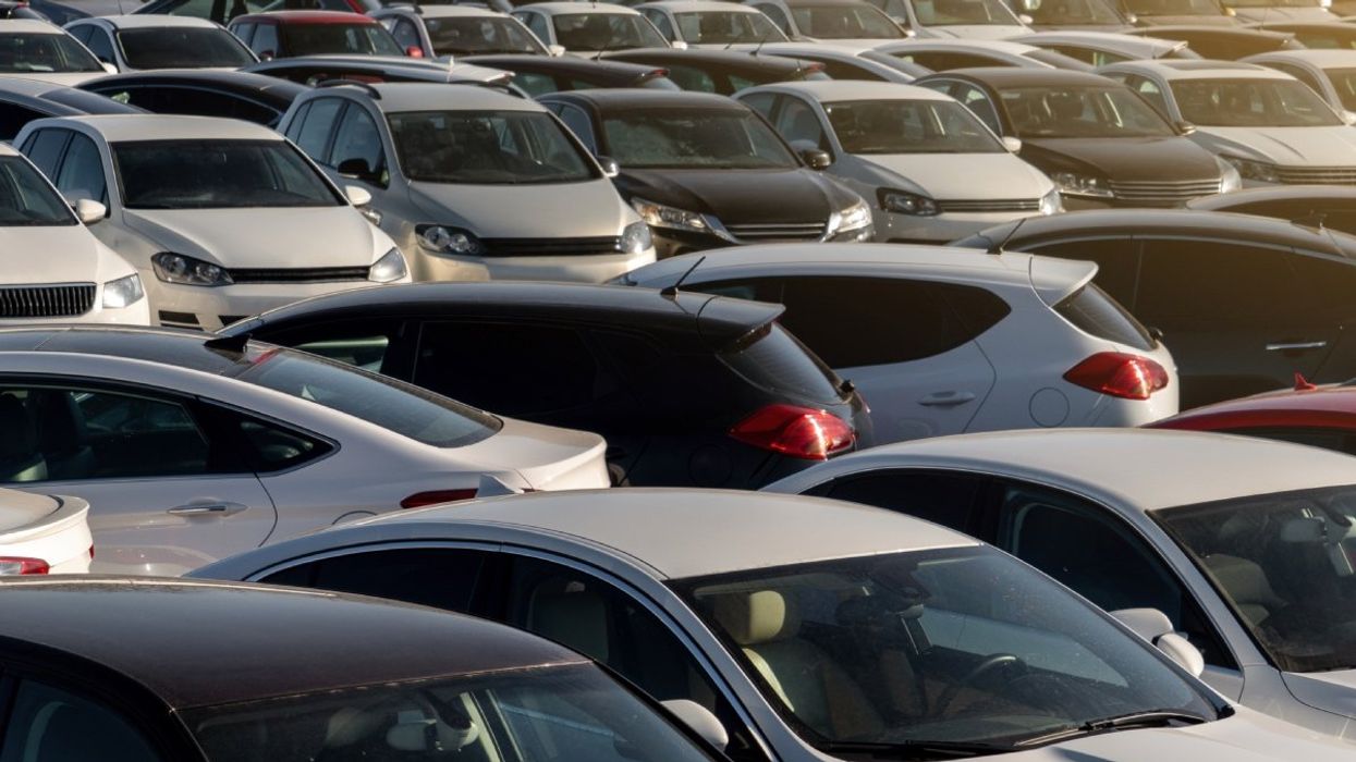 A number of cars parked in a lot.