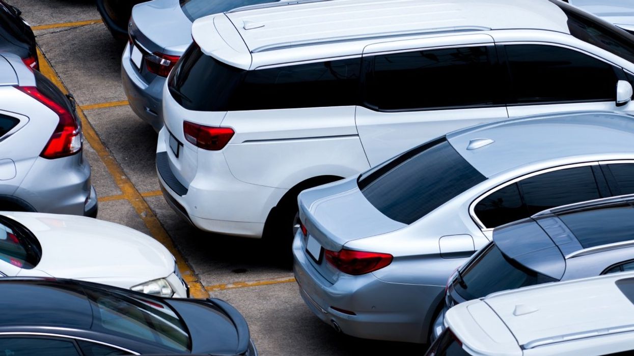 A number of cars parked into a parking lot.