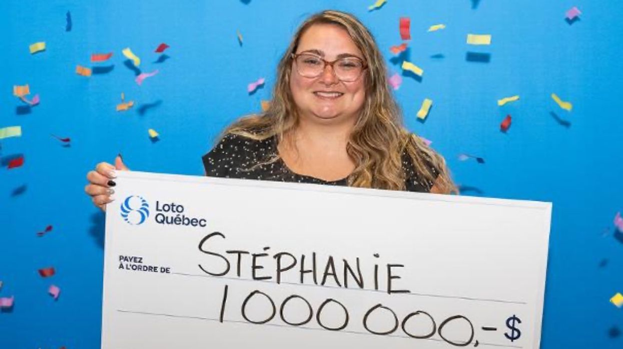 A person holding a giant cheque for $1 million at the Loto-Quebec headquarter after winning the Maxmillions Lotto Max lottery game.