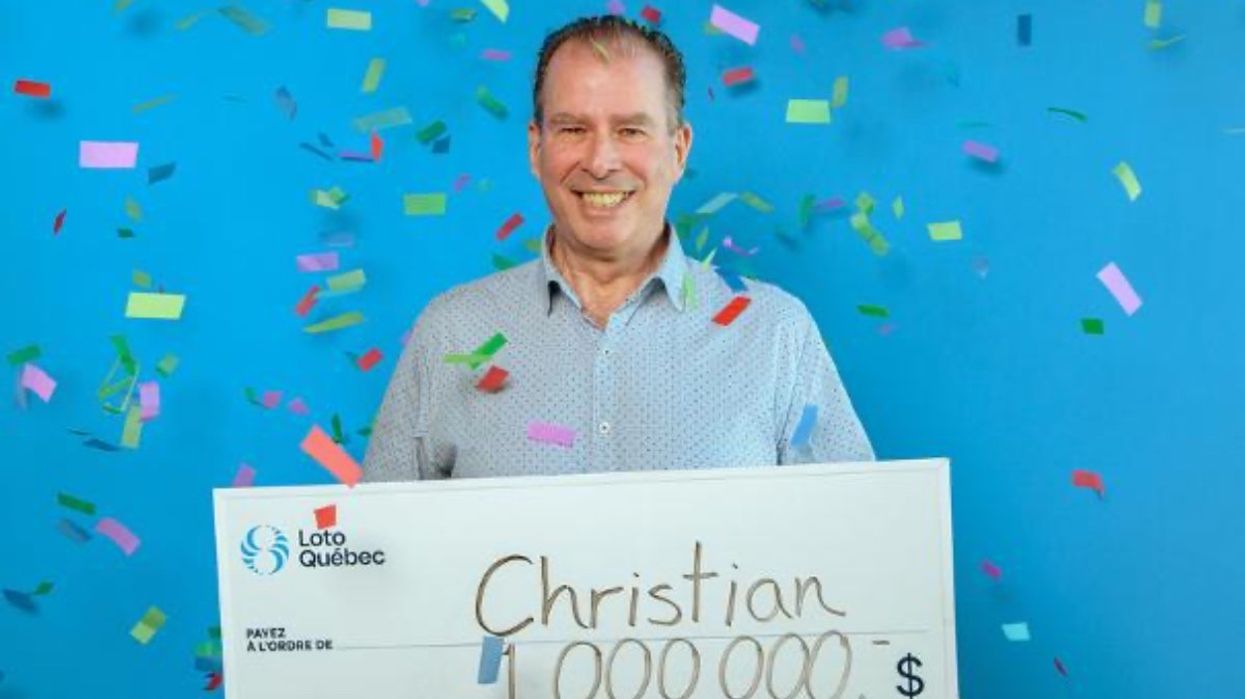 A person holding a giant cheque for $1 million at the Loto-Québec headquarters while confetti falls in the background.