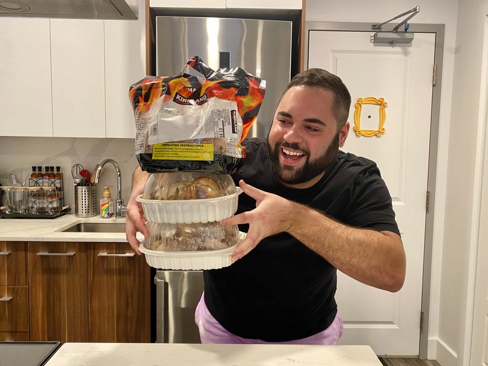 A person holding three rotisserie chickens from three different grocery stores.
