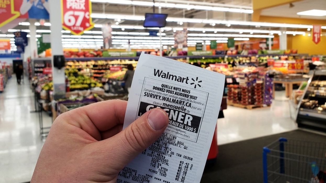 A person holding up a receipt from a Walmart superstore in Montreal, Quebec.